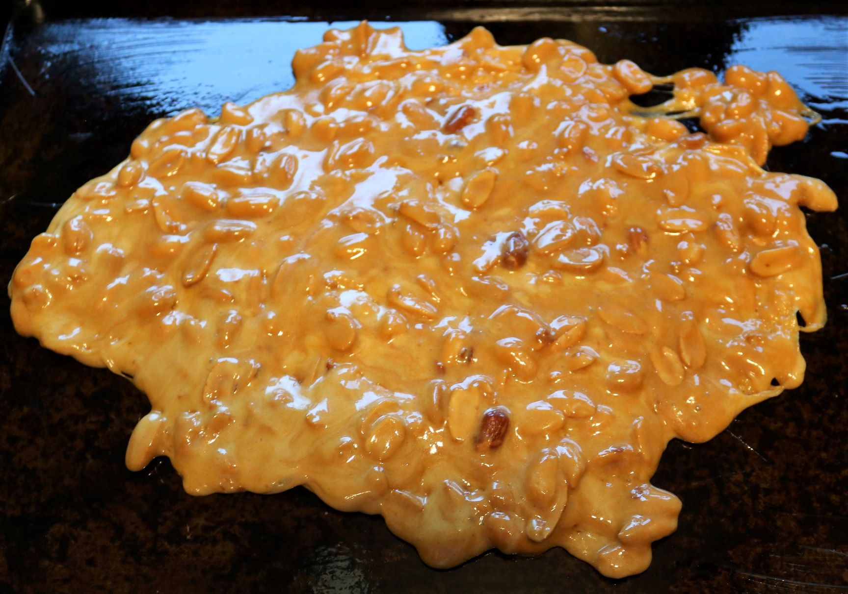 Cookie sheet with a sheet of peanut brittle on it.